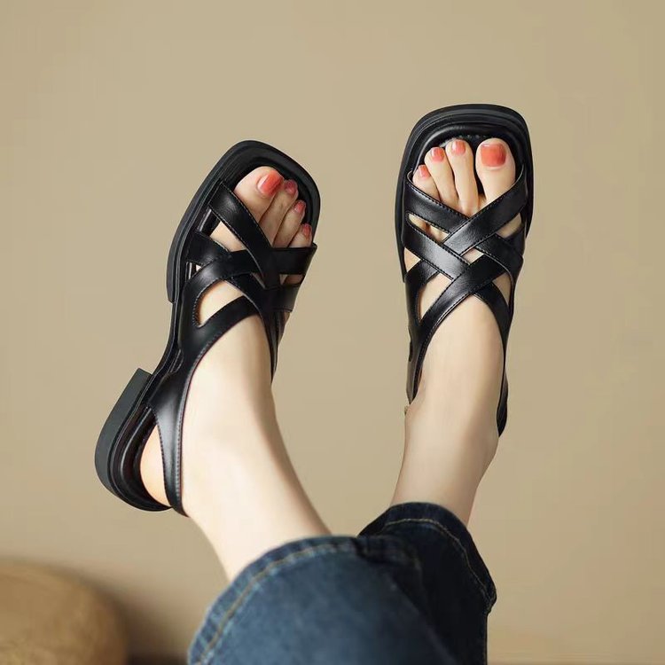 Black sandals worn with a neutral background